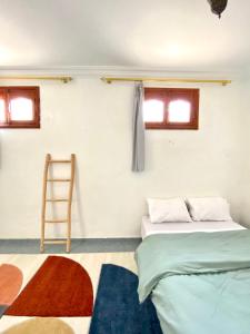 a room with two beds and a ladder in it at Surfpoint Tamraght in Tamraght Oufella