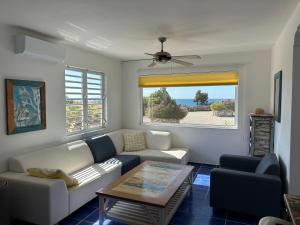 sala de estar con sofá y mesa en Marazul Dive Resort. 3 Bedroom Seafront House. Dive, Snorkel, enjoy amazing sunsets, en Westpunt