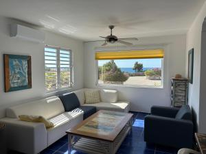 a living room with a couch and a table at Marazul Dive Resort. 3 Bedroom Seafront House. Dive, Snorkel, enjoy amazing sunsets in Westpunt