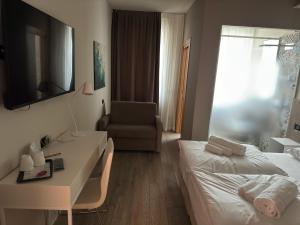 a hotel room with a bed and a desk and a chair at Ile Hotel in Peschiera del Garda