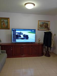 uma sala de estar com uma televisão de ecrã plano num centro de entretenimento em madeira em acasadimamma em Monterotondo