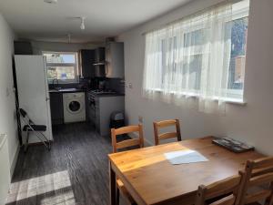 a kitchen and dining room with a wooden table and chairs at Lovely 2-Bed fully refurbished House in London in London