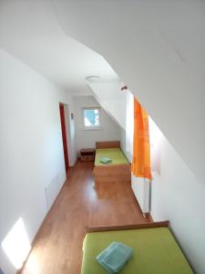 an attic room with two beds and an orange wall at Pokoje gościnne Na Wierchu in Kościelisko