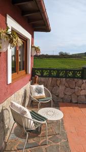 un patio con 2 sillas, una mesa y una ventana en Casa de campo La Casuca Del Monje en La Acebosa