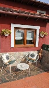 a group of chairs and a table in front of a building at Casa de campo La Casuca Del Monje in La Acebosa