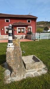 a lighthouse on a rock in front of a house at Casa de campo La Casuca Del Monje in La Acebosa