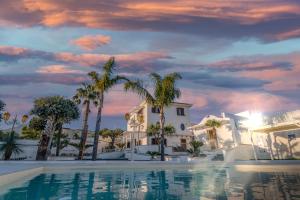 una piscina di fronte a una casa con palme di Villa Vesuvio a Boscotrecase