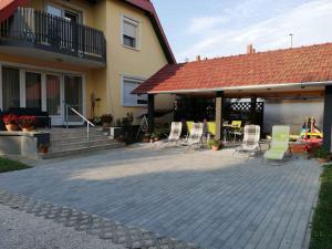 a patio with chairs and tables and a building at Holiday home Balatonbereny - Balaton 18030 in Balatonberény