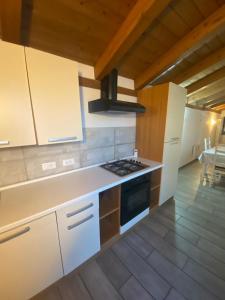 una cucina con armadi bianchi e piano cottura di Apartments Il Delfino ad Aosta