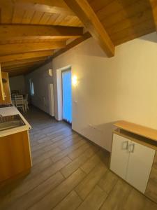 a kitchen with wooden floors and wooden ceilings and a room at Apartments Il Delfino in Aosta