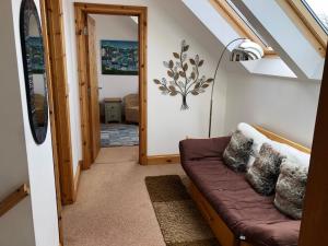 a living room with a brown couch in a room at Penlan Coastal Cottages in Aberporth