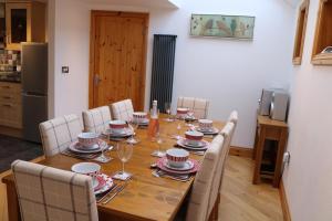 a dining room with a table with chairs and a tableablish at Penlan Coastal Cottages in Aberporth