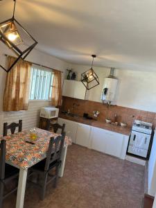 a kitchen with a table with chairs and a table and a table and a kitchen at lahabanadepartamento in Villa Carlos Paz