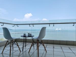 Un balcón con mesa y sillas y vista al mar. en Invincible Seaview Vacation Condo 3R3B 8Pax, en Bayan Lepas