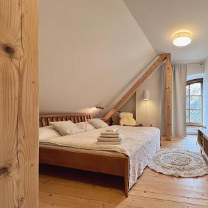 a bedroom with a large bed with white sheets at Kaple svaté Markéty in Žďár nad Sázavou