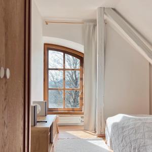 um quarto com uma cama e uma janela em Kaple svaté Markéty em Zďár nad Sázavou