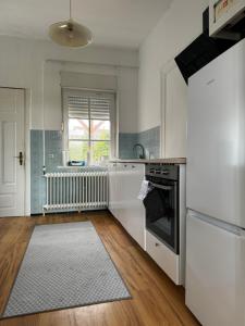 a kitchen with white appliances and a wooden floor at Ferienhaus in Wilster / Monteure 