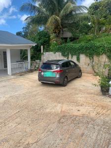 a car parked in a driveway in front of a house at Villa les MAHOGANYS in Rivière-Salée