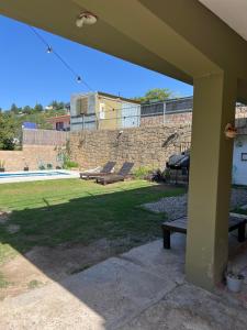 a patio with a table and a bench in a yard at lahabanadepartamento in Villa Carlos Paz