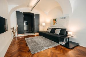 sala de estar con sofá negro y alfombra en Mart's Choice Apartment en Liubliana