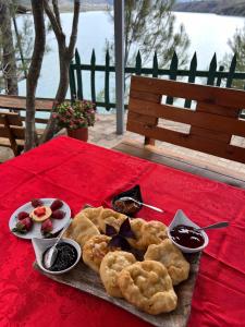 una mesa con un plato de comida en un mantel rojo en Lundra, en Gramsh