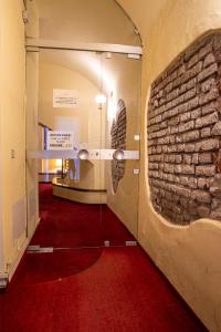 un couloir avec un mur en briques et un miroir dans l'établissement Atriums Apartment Quovis Domus, à Turin