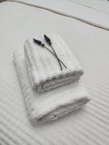 two white towels with a flower on a bed at Villa María Montecastillo Golf in Jerez de la Frontera