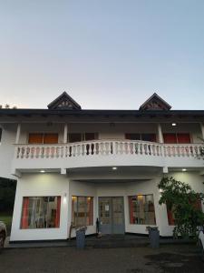 ein weißes Gebäude mit Balkon darüber in der Unterkunft Hotel Puerto Libertad - Iguazú in Puerto Libertad