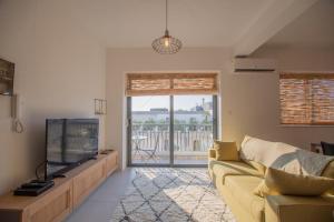 a living room with a couch and a flat screen tv at Sunset in Marsaskala