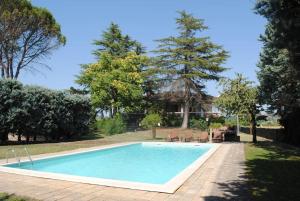 uma piscina num quintal com árvores e uma casa em VILLA MOLINI em Magione