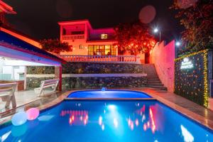 a swimming pool in front of a house at night at Villa downtown jarabacoa in Jarabacoa