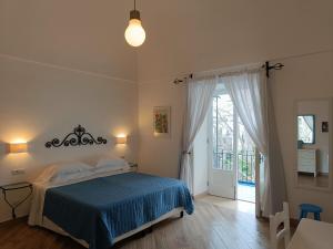 a bedroom with a bed with a blue blanket at Regina Margherita in Positano