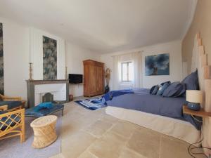 a bedroom with a blue bed and a fireplace at La Promenade Suite & Spa in Congéniès