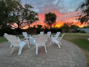 a group of white chairs and a table with a sunset at Luxurious 4-bedroom home in Scottsdale in Scottsdale