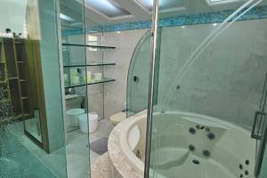 a bathroom with a shower and a bath tub at Luxo e conforto à beira-mar em canto nobre da praia in Guarapari