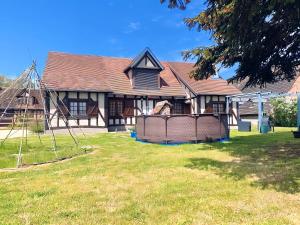 a house with a yard with a fence in front of it at La demeure du Cerf gîte de charme privatif 6P en Sologne Jacuzzi Piscine chauffée sud Orléans Beauval in Chaon