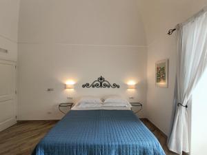 a bedroom with a bed with a blue blanket at Regina Margherita in Positano