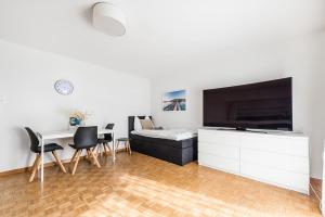 een woonkamer met een tafel en een grote tv bij Cooldis G in Kreuzlingen