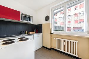 een keuken met een wit fornuis top oven naast een raam bij Cooldis G in Kreuzlingen