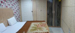 Una habitación con una cama con una alfombra. en H-J Family Hotel en Lahore