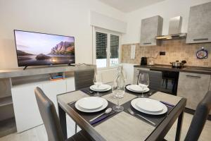 een keuken met een eettafel en 2 wijnglazen bij Appartamento Moderno per 6 Aviano A/C Parking in Aviano