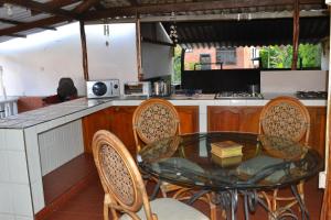 eine Küche mit einem Glastisch und Stühlen in der Unterkunft Casa Verde Chalet in La Tebaida