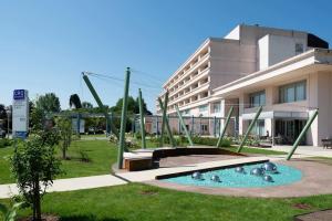 een gebouw met een zwembad voor een gebouw bij Appartamento Moderno per 6 Aviano A/C Parking in Aviano