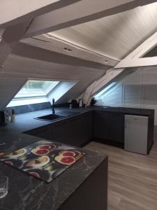 an attic kitchen with a sink and a counter at Residence du parc in Saint-Martin-dʼUriage