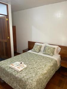 a bedroom with a bed with two towels on it at Hospedaje Familiar Laos in Oxapampa