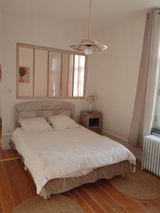 a bedroom with a white bed with a window at Charme D Antan in Villers-Châtel