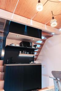 een keuken met een zwart aanrecht en houten plafonds bij demimaisons in Esneux