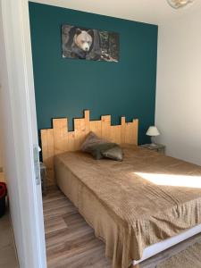 1 dormitorio con 1 cama grande y pared azul en CHALET en RDJ en VALLEE de LUCHON, en Castillon-de-Larboust