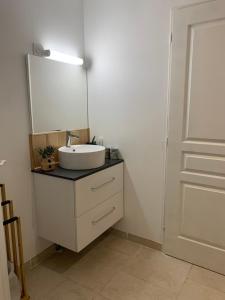 La salle de bains est pourvue d'un lavabo et d'un miroir à côté d'une porte. dans l'établissement CHALET en RDJ en VALLEE de LUCHON, à Castillon-de-Larboust 12 autres photos