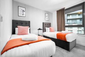 1 dormitorio con 2 camas y ventana en Luxury City Centre 2 Bedroom Apartment - Secure Parking - Balcony - Top Rated - 377P en Birmingham